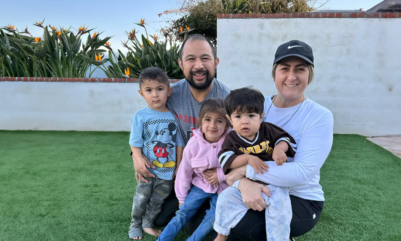 A family of five smiling and posing in a backyard, symbolizing unity and support for Rett syndrome awareness